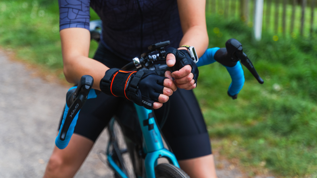 Cyclist wearing fingerless gloves holding handlebars.