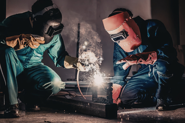 Two workers welding in a factory