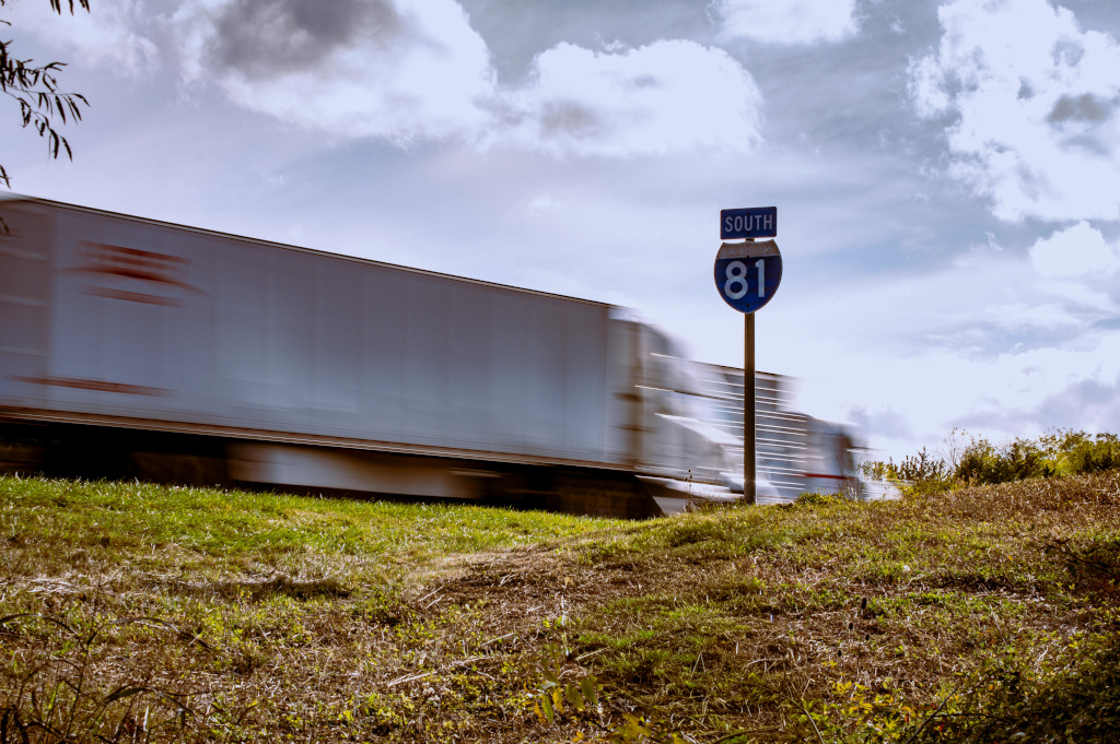 Large moving truck on an interstate highway at sunset